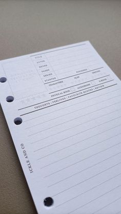 a close up of a white piece of paper on a table with some black dots