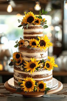 a three tiered cake with sunflowers on top