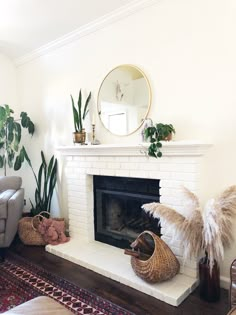 a living room filled with furniture and a fire place in front of a mirror on the wall