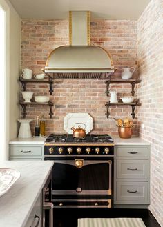 a stove top oven sitting inside of a kitchen next to a wall mounted range hood