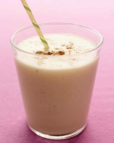 a drink with a straw sticking out of it's top sitting on a pink surface