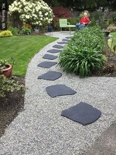 a garden path with stepping stones in the middle