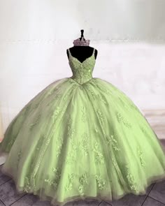 a green ball gown is displayed on a mannequin headdress in front of a white wall