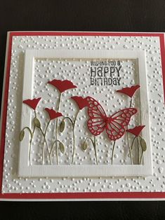 a handmade card with red flowers and a butterfly on the front, says wishing you a happy birthday