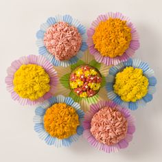 cupcakes with colorful frosting and sprinkles arranged in the shape of a flower