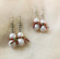 two pairs of white pearls and red beads on silver earwires, with green bead accents