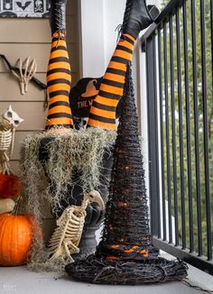 halloween decorations on the front porch with pumpkins and skeletons in witch hats, striped socks and black stockings