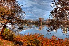 the city skyline is reflected in the still waters of this beautiful autumn day's lake