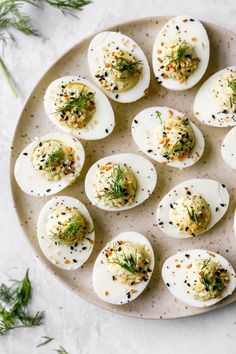 deviled eggs with herbs and seasoning on a plate