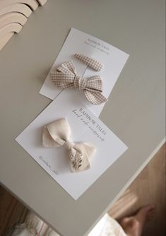 two small bows are sitting on top of a card