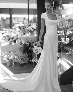 a woman in a wedding dress is posing for the camera