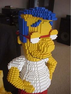 a lego model of the simpsons is made out of legos and has been placed in front of a couch