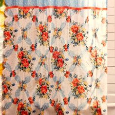 the shower curtain is decorated with flowers and blue trim on it's edge, along with an orange flowered border