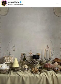 a table topped with lots of different types of food and candles on top of it