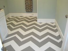 a bathroom with gray and white chevron flooring