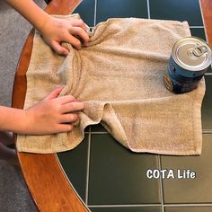 someone is cleaning the cloth on top of a table with a can of soda in it