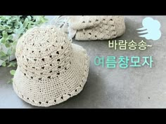 a hat and booties are sitting on the ground next to some plants with words written in korean