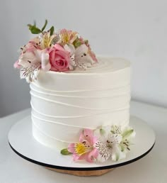 a white cake with pink flowers on top