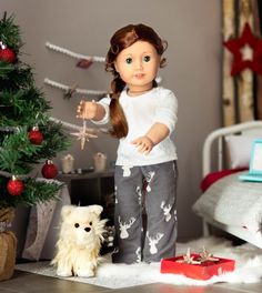 a doll standing next to a christmas tree