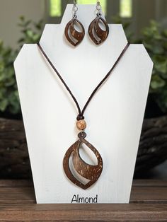 "These elegant earrings and necklaces are hand-carved from coconut shell and made in Sri Lanka, a well-known island for quality coconut shell products. The color of a coconut shell ranges from dark brown to light brown with some areas of pale creamy shades that result in beautiful unique colors and variations in the final earrings/ pendants (colors may slightly vary from the pictures).  The final product is smoothed and heavily polished. Earrings are hung from a silver hoop and pendants are hung from a cord to give the perfect look you want!! Cord length - 17\" Variations & Sizes: - Almond (Pendant H - 2.5\", W - 2\", Earrings  H - 1.2\", W - 1\") - Spotify (Pendant D - 2\", Earrings  D - 1.2\") - Light on Dark (Pendant D - 2\", Earrings  D - 1\") - Dark on Light (Pendant D - 2\", Earrings Coconut Shell Products, Seashell Jewelry Diy, Coconut Jewelry, Coconut Shell Crafts, Natural Necklace, Wood Jewelery, Tropical Jewelry, Nature Necklace, Earrings Summer