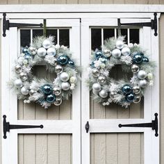 two christmas wreaths hanging on the side of a white door with silver and blue ornaments