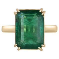 Displayed is a classic emerald solitaire engagement or right-hand ring. This spectacular piece features a remarkable 7.25-carat, natural emerald cut emerald from the origins of Zambia. The center stone showcases a rich green color that enthralls at first glance. Minor imperfections are normal in earth-mined gems though this gem is very eye clean. Carefully set in secure, double prong 18K yellow gold setting. Setting Style: Prong Setting Material: 18K Yellow Gold Main Stone: Emerald Shape: Emerald Cut Weight: 7.25-Carats Clarity: Transparent Color: Deep Green Luster: Very Good Treatments: Natural, Oiling Origin: Zambia Estimated Retail Value: $24,190.00 USD Emerald Gold Ring, Engagement Ring Classic, Ring Emerald Cut, Emerald Gem, Claw Prong, Ring Emerald, Etsy Gold Ring, Right Hand Rings, Hand Ring