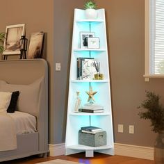 a tall white shelf sitting in the corner of a living room next to a bed