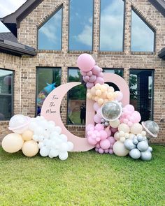 a large letter decorated with balloons in front of a house