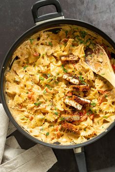 a pan filled with pasta and chicken on top of a table