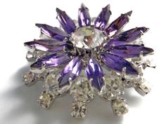 Stunning large vintage unsigned amethyst and clear rhinestone flower brooch costume jewelry. Stunning piece with clear and bright stones with rhodium plating. This is a reticulated, mult-tiered brooch with the lower level consisting of large brilliant faceted crystal. The upper tier are the marquis amethyst stones representing the colored petals of a flower. Really impressive size and design. Vintage Flower Brooch - Purple Rhinestones - Clear Marquis Crystals - Brilliant Cut Rhinestones - Februa February Aquarius, Aquarius Birthstone, Jewelry Brooch, Rhinestone Flower, Purple Rhinestone, Vintage Purple, Faceted Crystal, Vintage Bracelets, Amethyst Stone