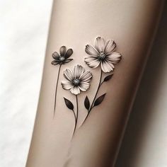 some flowers are on the side of a woman's leg with black and white ink