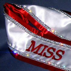 a red and white satin bag with the word miss on it's front side