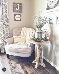 a white chair sitting next to a table with flowers on top of it in front of a window