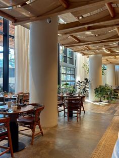 an empty restaurant with tables and chairs in front of large windows on the outside wall