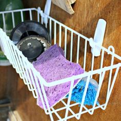 a white wire basket filled with cleaning supplies