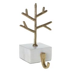 a gold metal tree on a white block