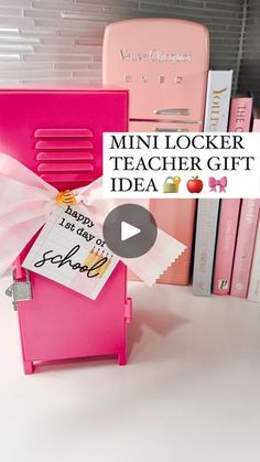 a pink locker sitting on top of a white table next to books and binders