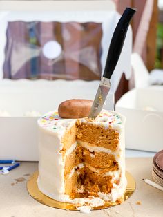 a knife sticking out of a cake with white frosting