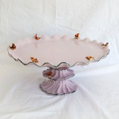 a pink and white platter with ladybugs on it