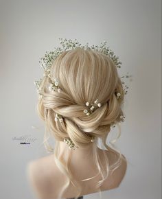 the back of a woman's head with flowers in her hair and pearls on it