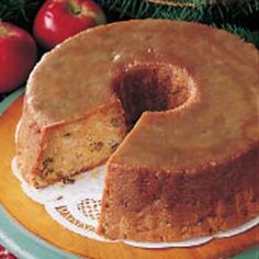 a bundt cake with one slice cut out on a plate next to some apples