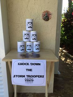 a table with some cups on it and a sign that says knock down the storm troopers