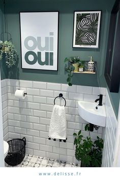 a bathroom with green walls and white tile flooring is pictured in this image, there are plants on the shelf above the sink