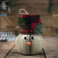 a snowman made out of an old book is sitting on a wooden table,