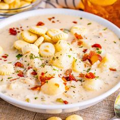 a white bowl filled with soup and crackers on top of a table next to other food