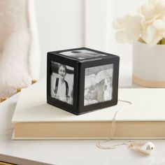 a black and white photo cube sitting on top of a table next to a book