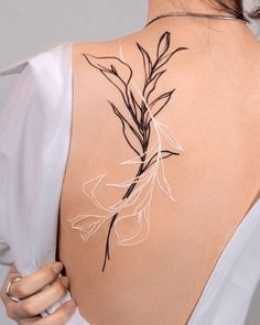 the back of a woman's shoulder with an artistic tattoo design on her upper arm