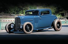 an antique blue car parked in a parking lot