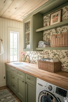 a washer and dryer in a small room with green cabinets, floral wallpaper