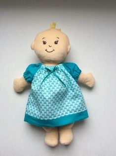 a small stuffed doll with a blue dress